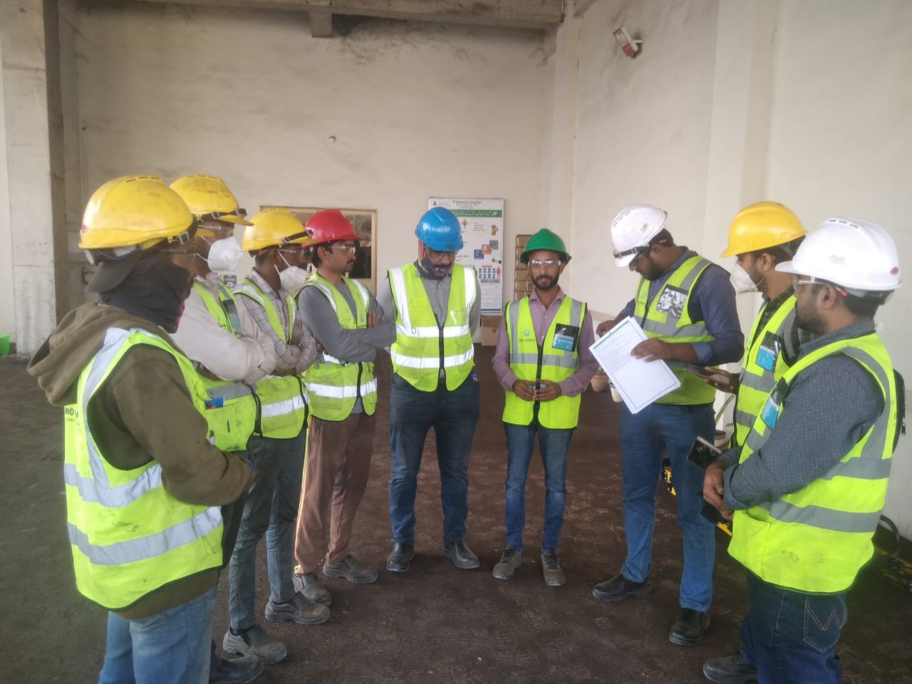 Techno Control Corporation technical service team in green safety uniforms conducting an on-site inspection.